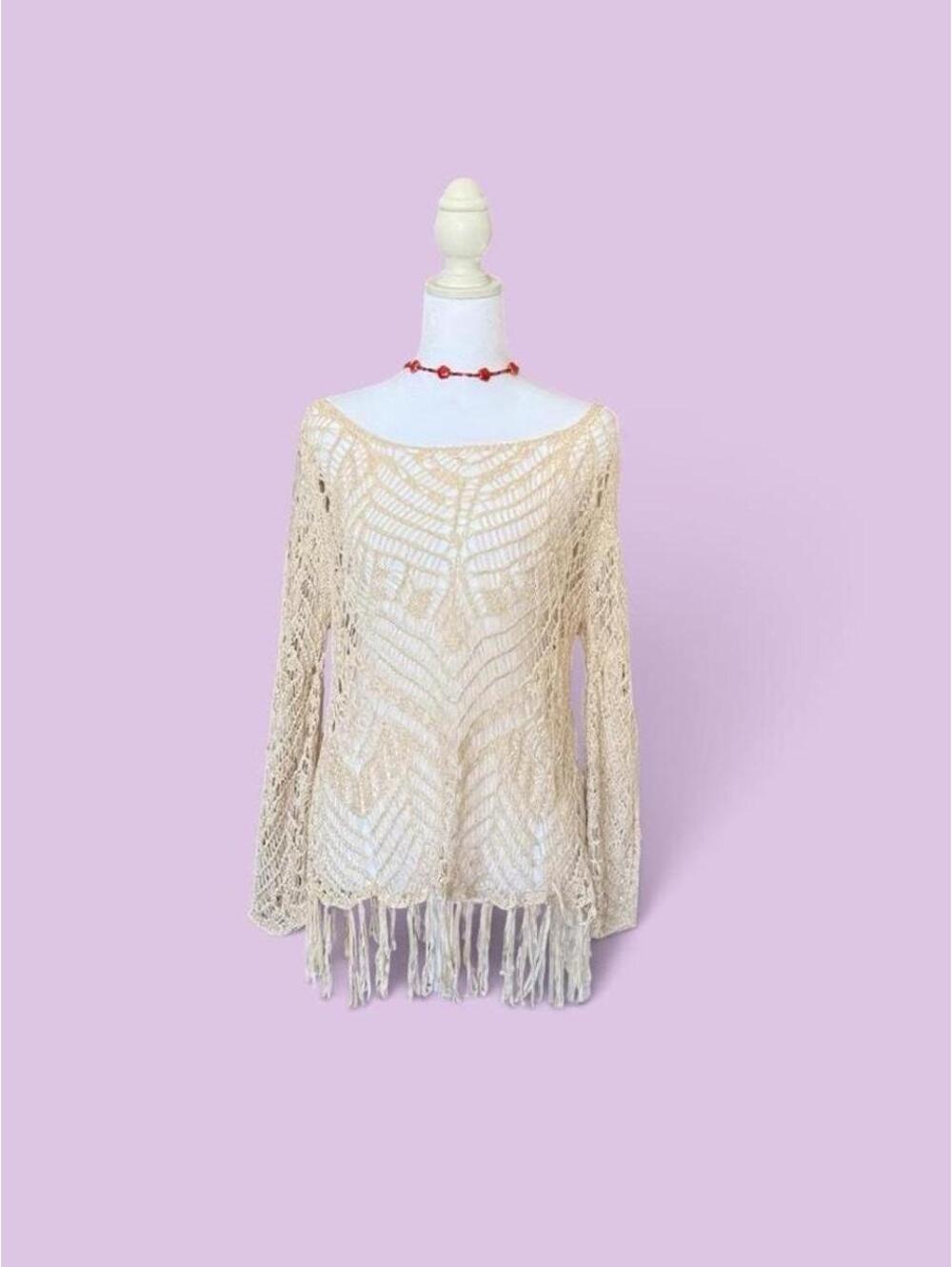 Cream crochet top with fringe hem.